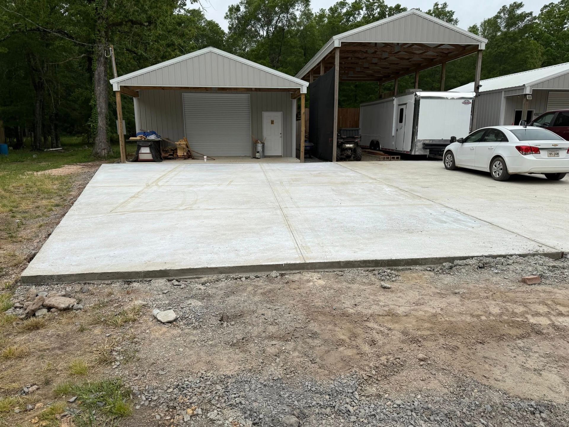 A white car is parked in a driveway next to a garage.