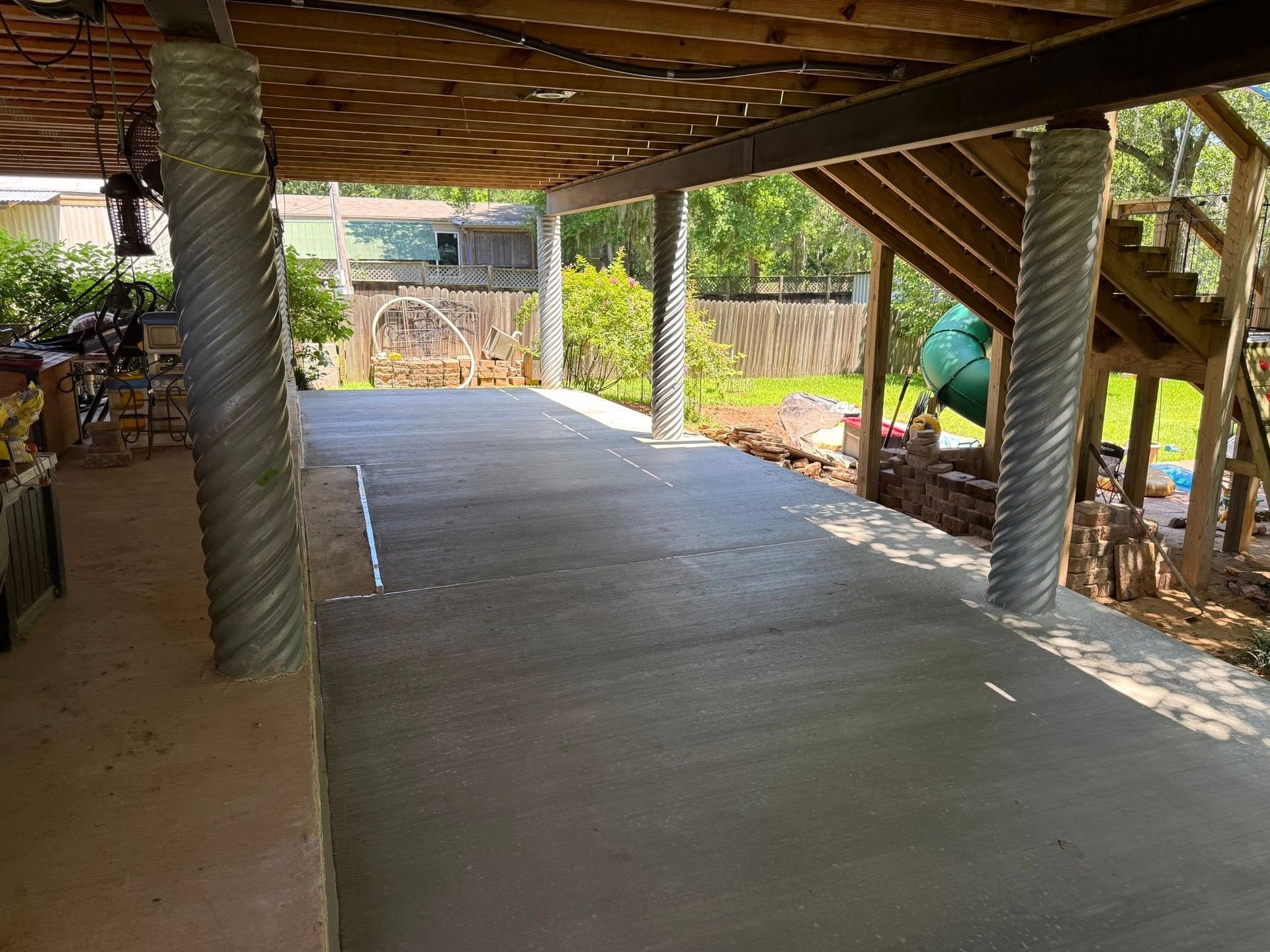 A covered walkway leading to a house with a slide in the background.