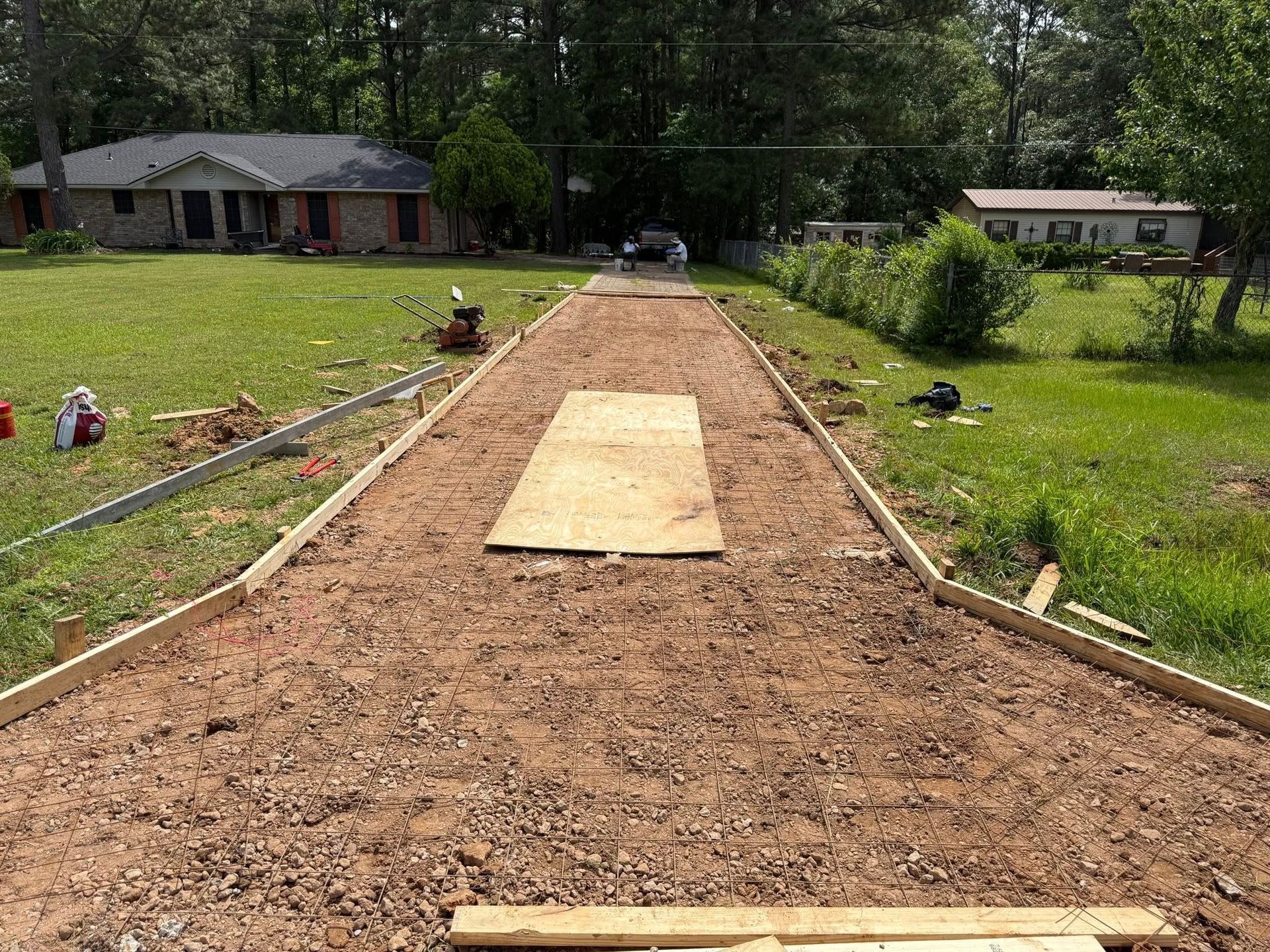 A dirt road is being built in front of a house.