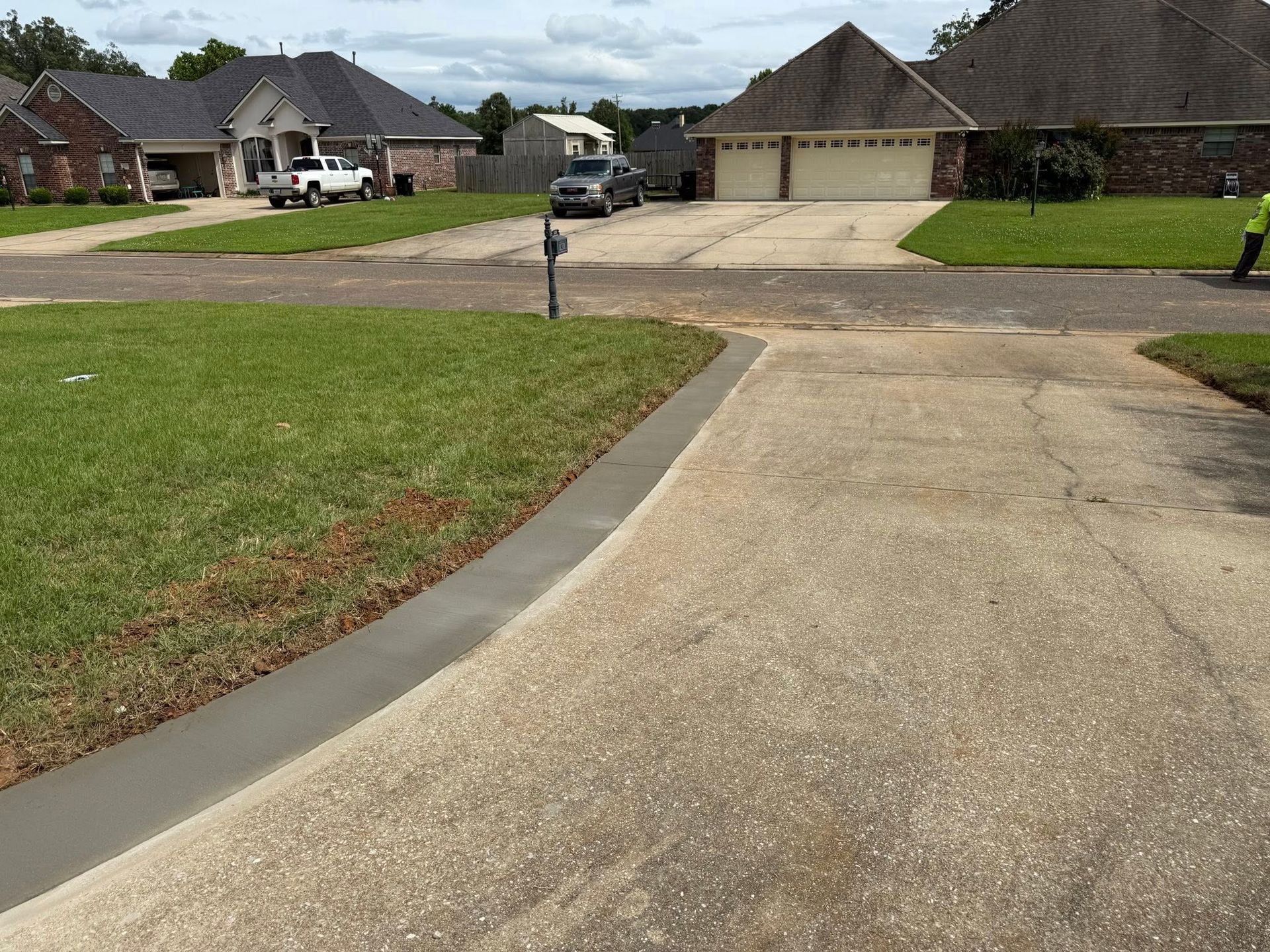 A concrete driveway is being built in a residential neighborhood