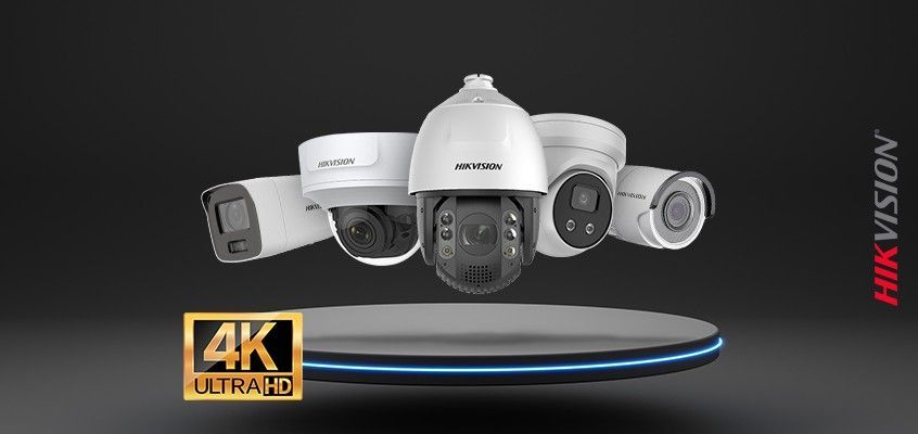 Hikvision-beveiligingscamera's weergegeven op een rond platform. 4K Ultra HD-tekst. Donkere achtergrond.