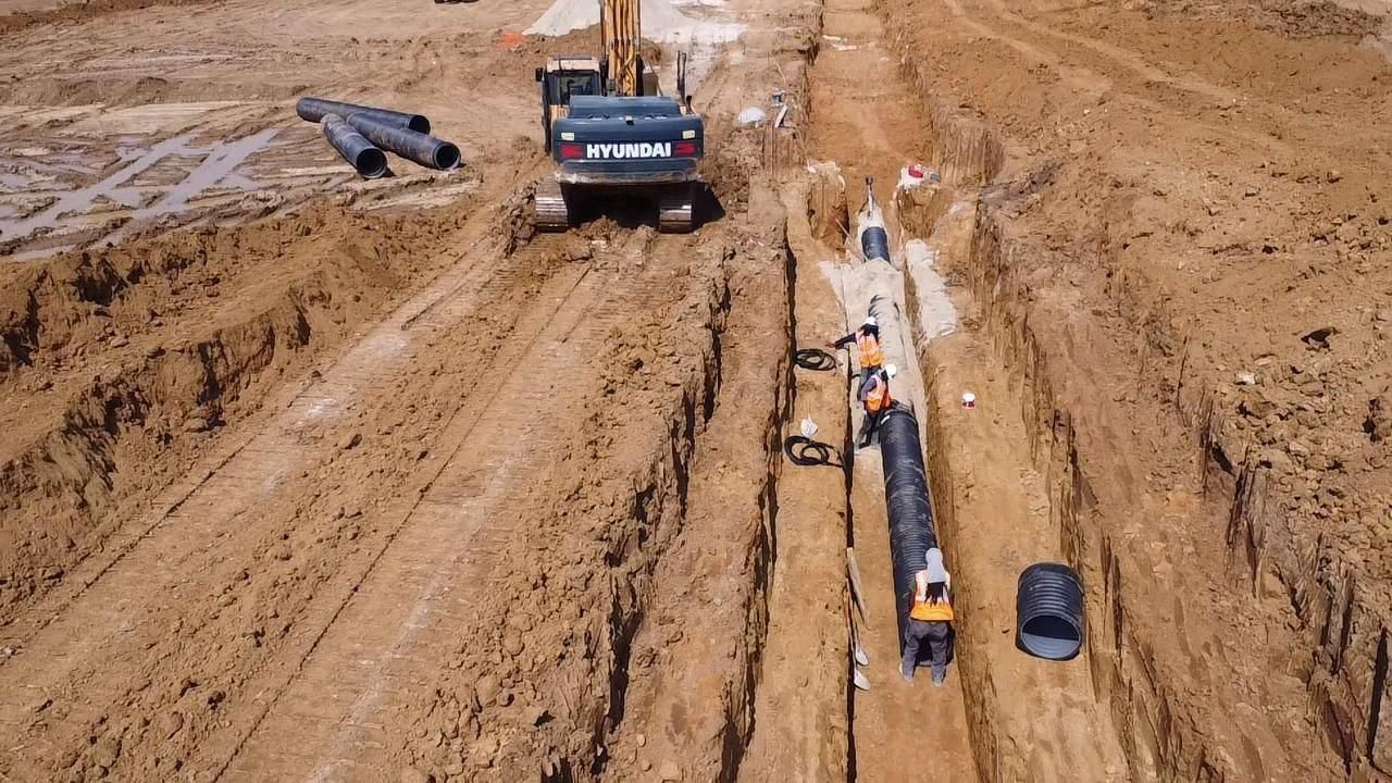 Une vue aérienne d'un chantier de construction avec des tuyaux en cours d'installation.