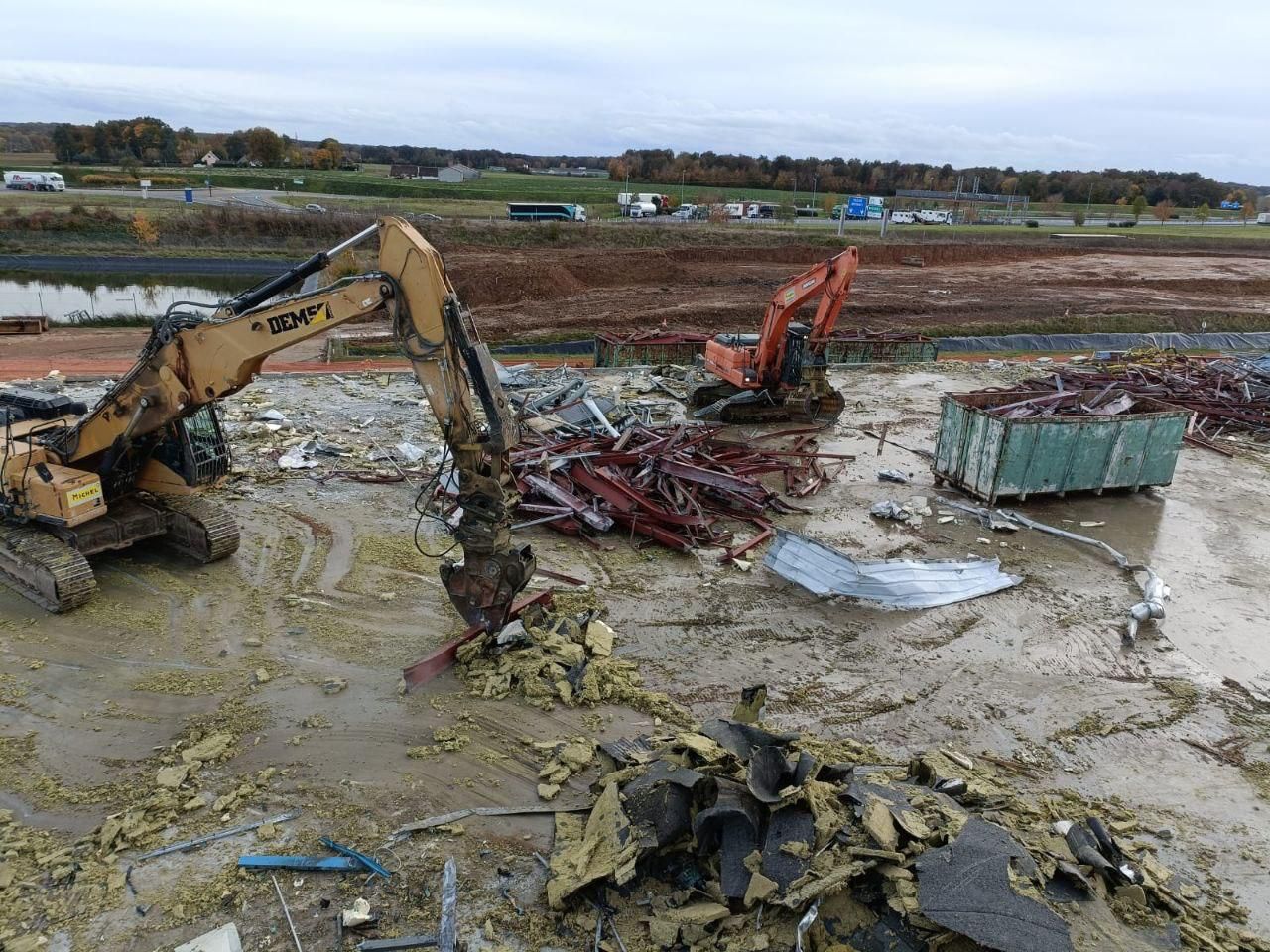 Une grande excavatrice est assise au milieu d'un champ boueux.