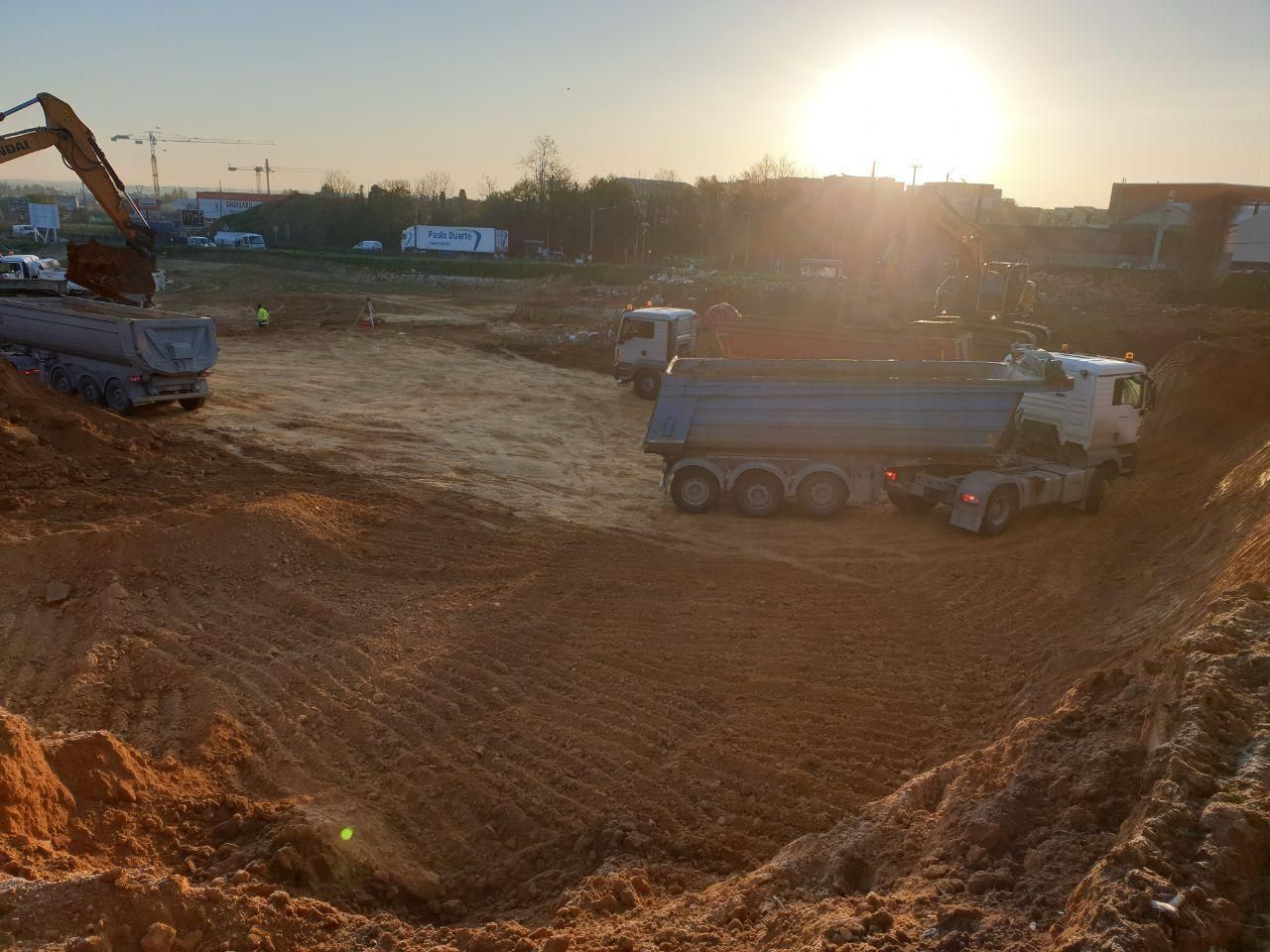 Un camion à benne basculante est chargé de terre sur un chantier de construction.