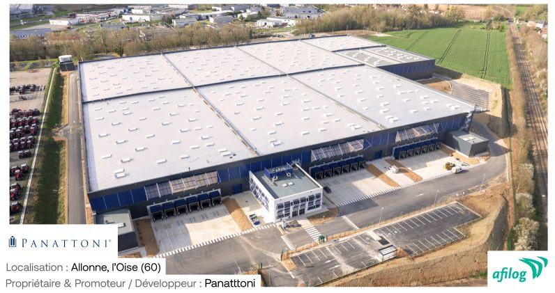 Une vue aérienne d'un grand entrepôt au toit blanc.