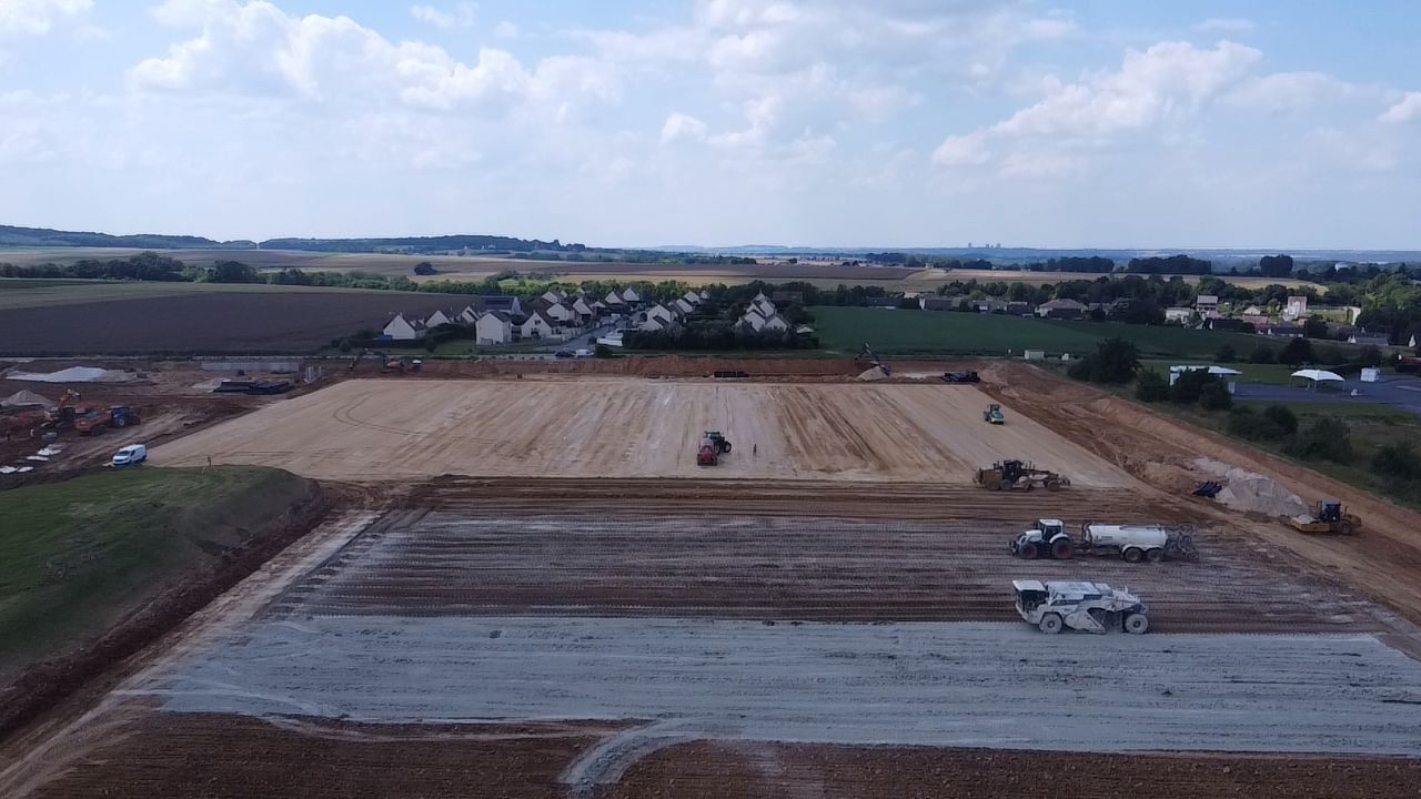 Une vue aérienne d'un chantier de construction au milieu d'un champ.