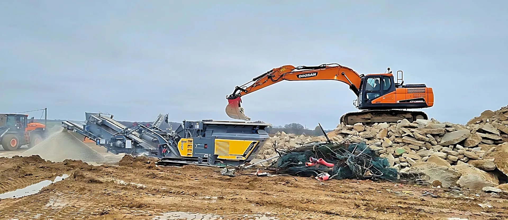 Une grosse excavatrice creuse dans un tas de terre.