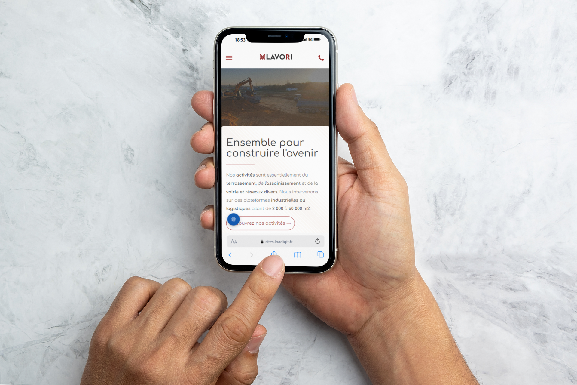 Une personne tient un téléphone portable à la main.
