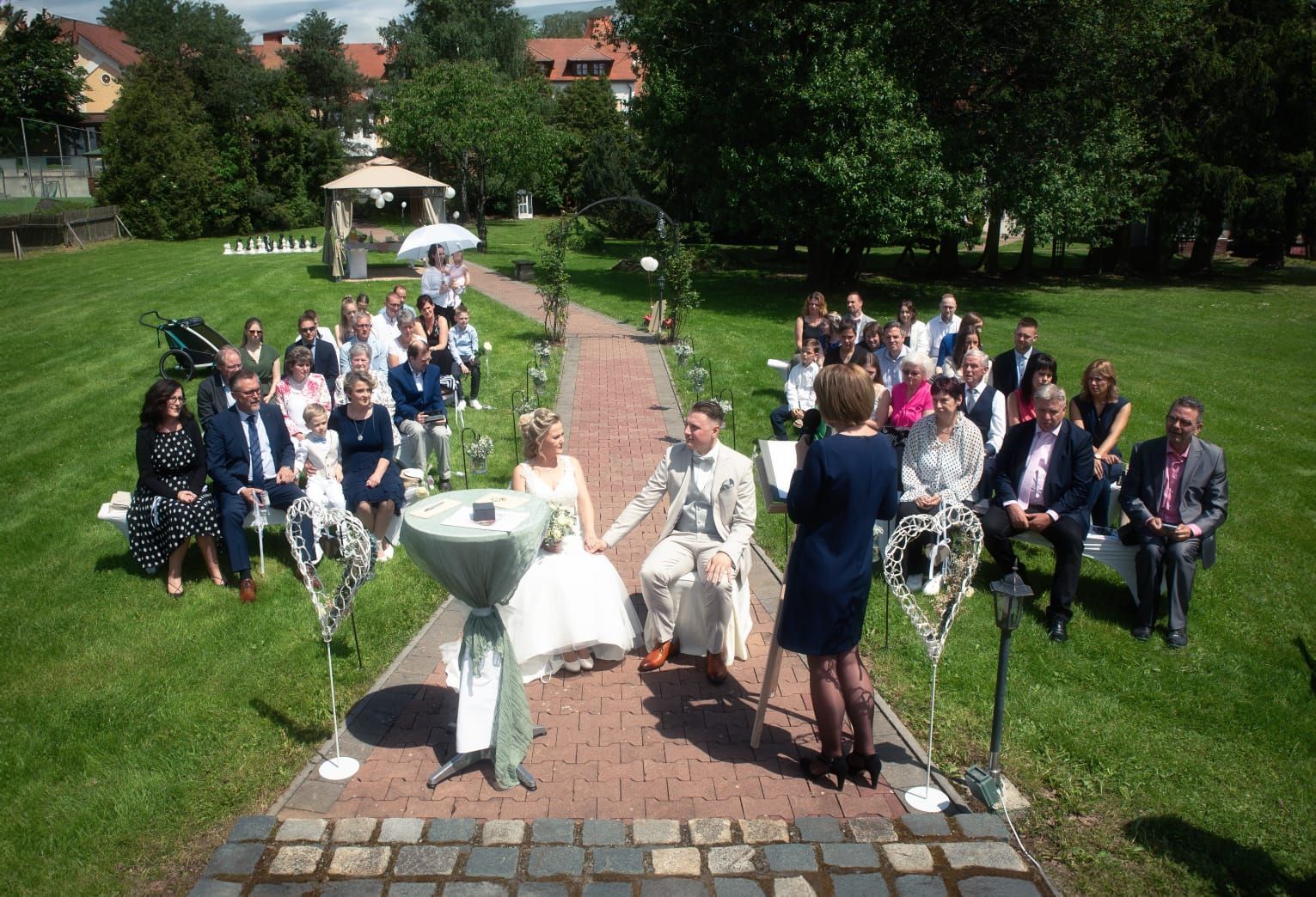 Eine Frau hält bei einer Hochzeitszeremonie in einem Park eine Rede.