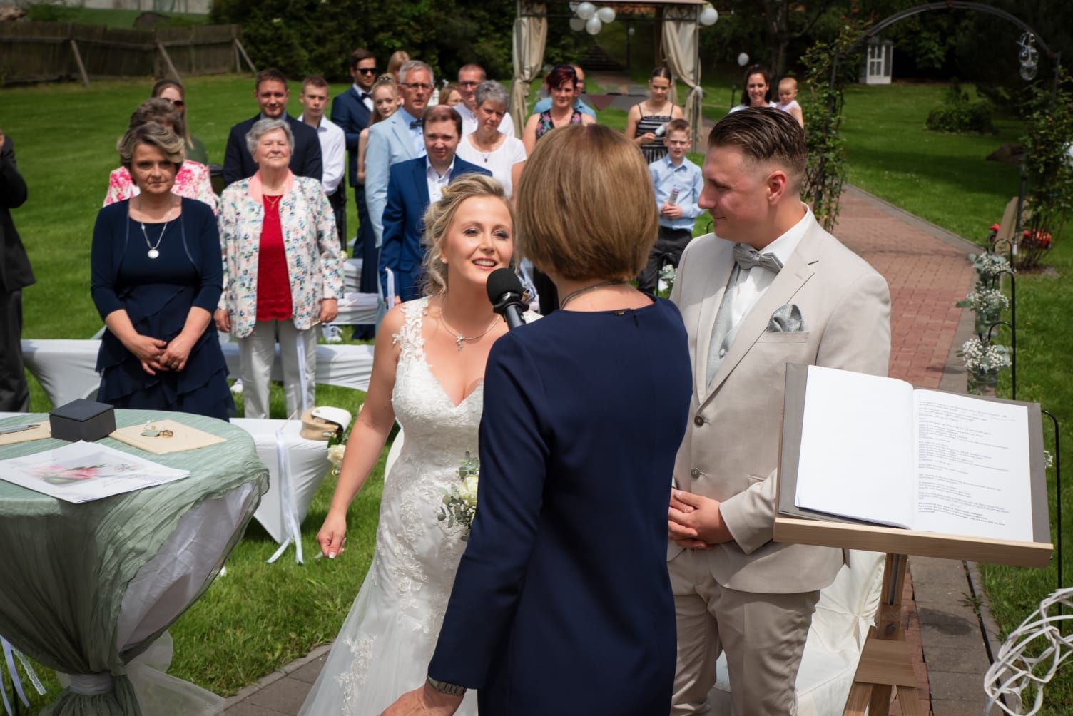 Eine Braut und ein Bräutigam heiraten vor ihren Hochzeitsgästen.