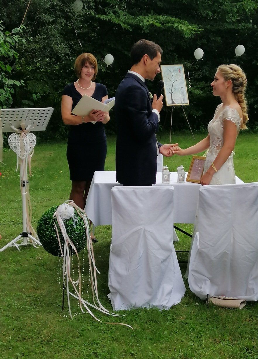 Eine Braut und ein Bräutigam halten bei ihrer Hochzeitszeremonie Händchen