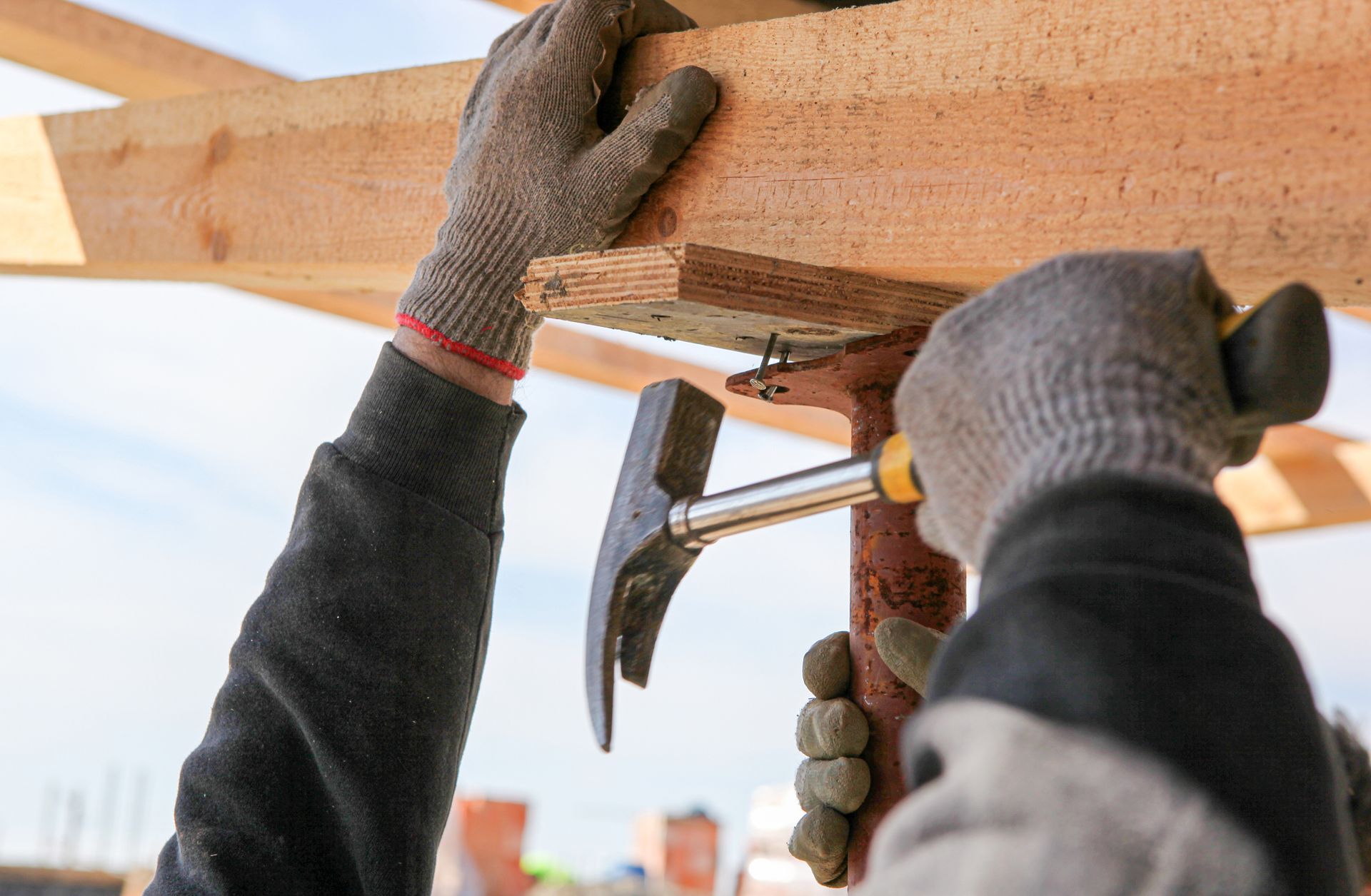 A man is using a hammer to hammer a piece of wood.