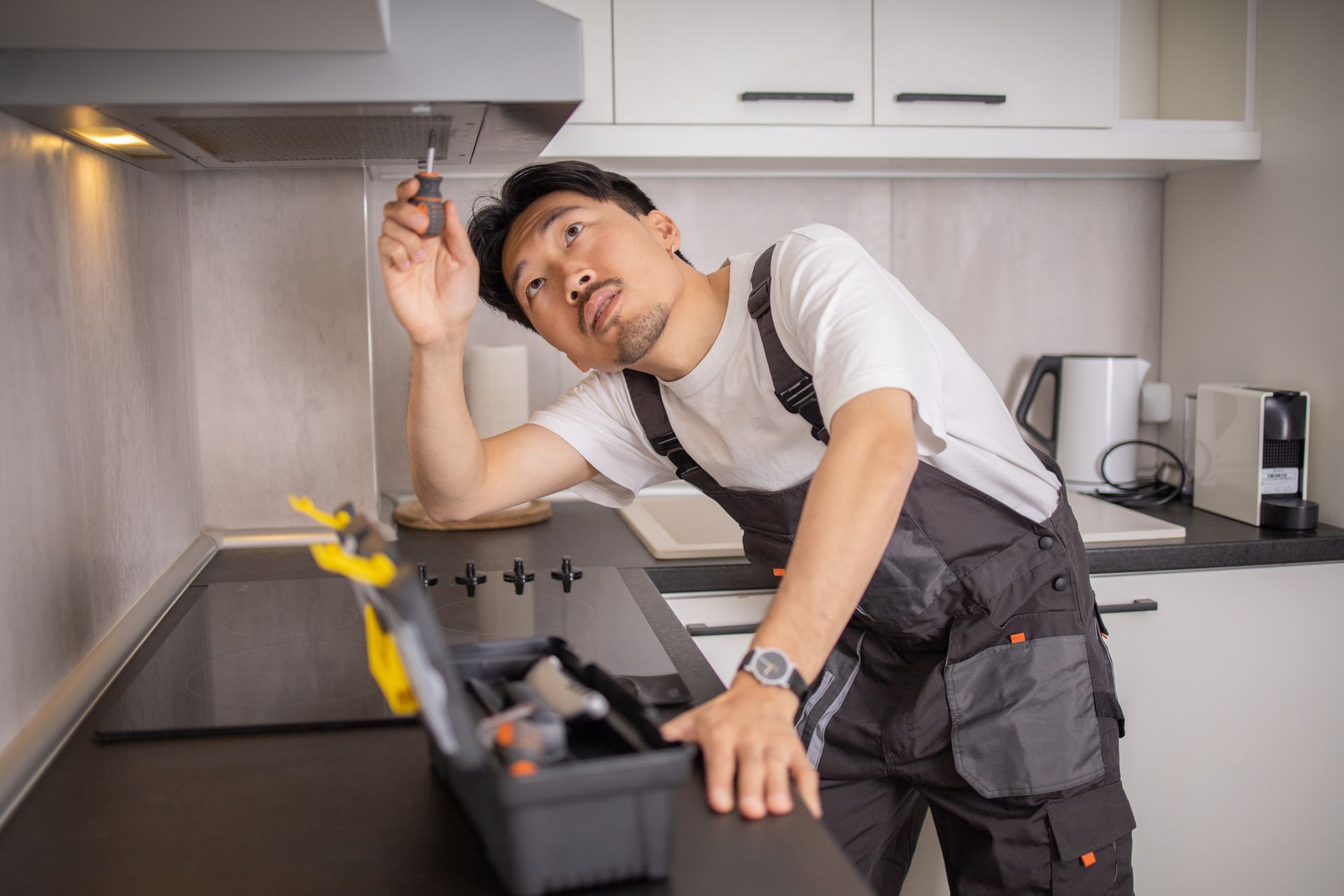 A person is cleaning the side of a house with a high pressure washer.