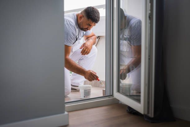 A man is painting a window with a brush.