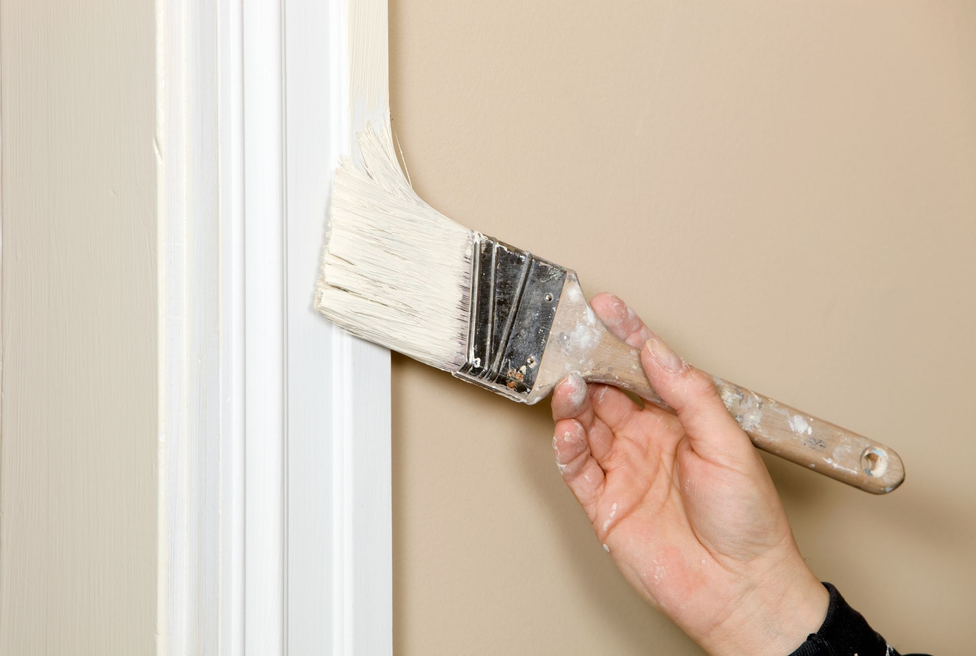 A person is painting a wall with a brush.