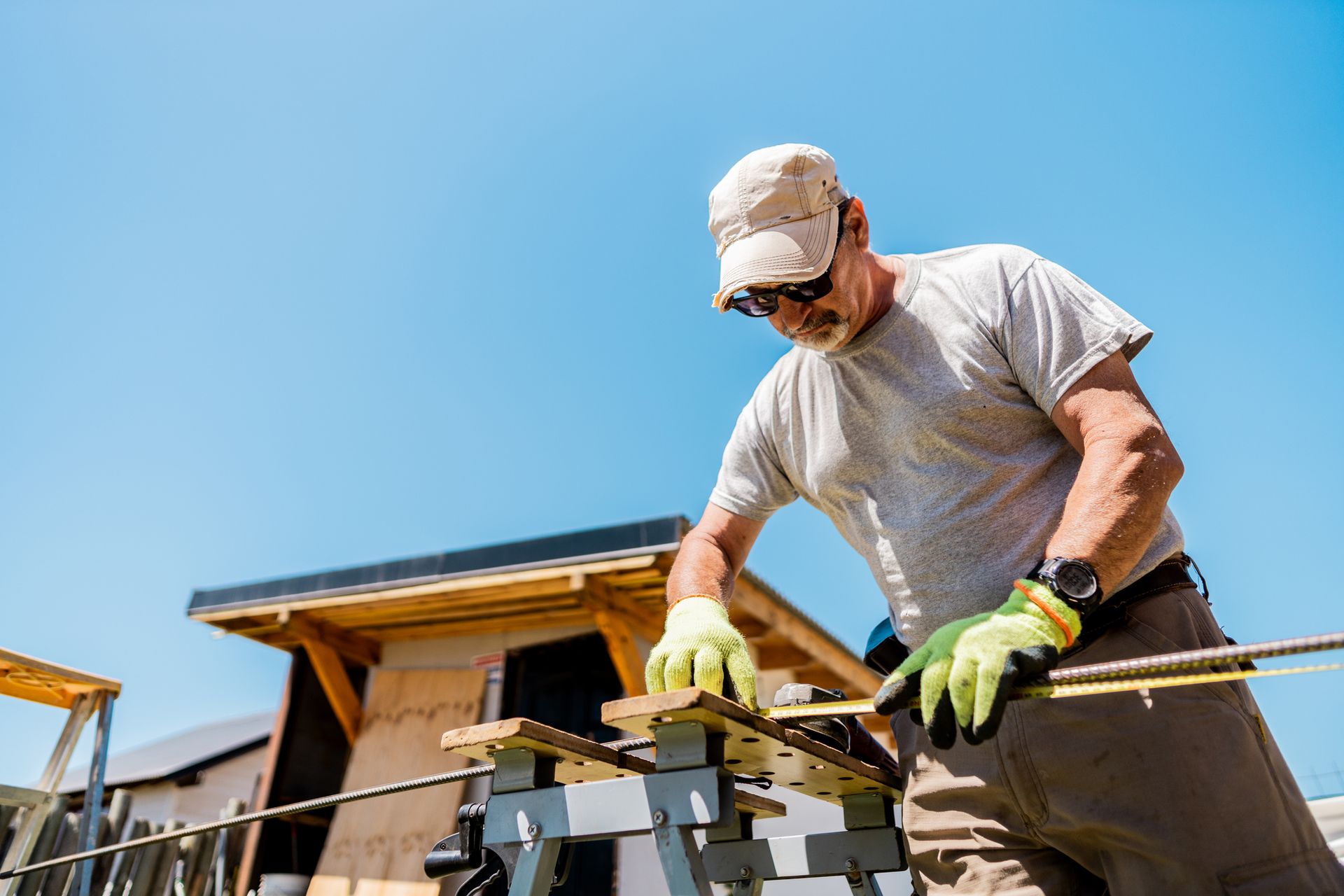 A man is cutting a piece of wood on a workbench.