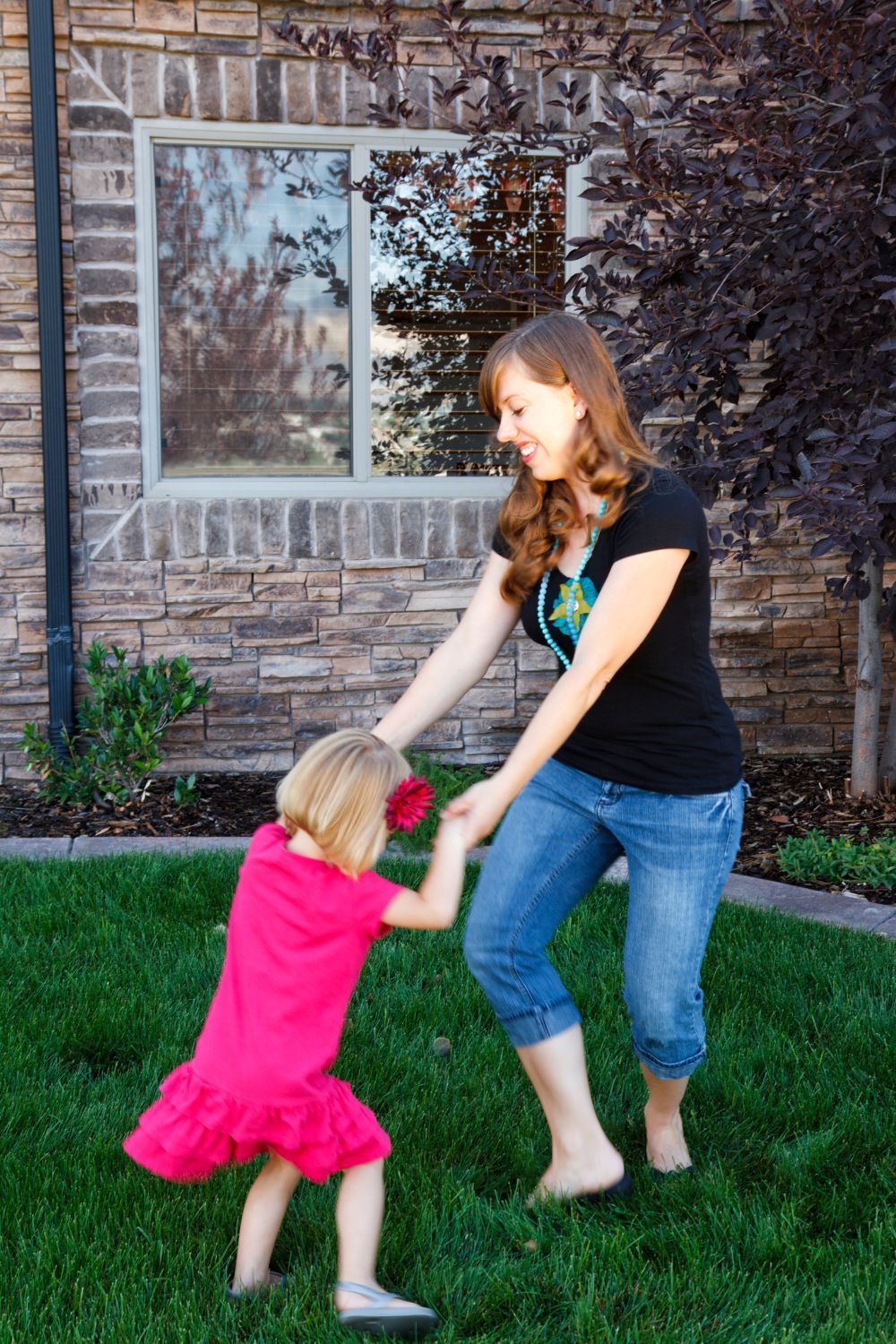 A mom and daughter dancing and smiling