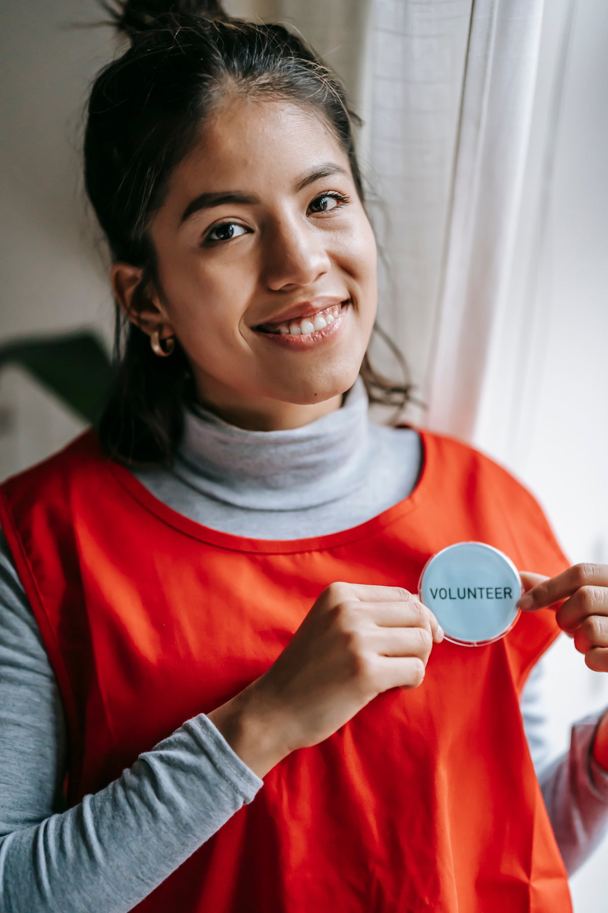 teen showing her volunteer badge