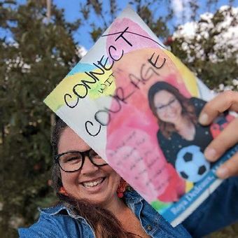 Roya Dedeaux holding copy of Connect with Courage book