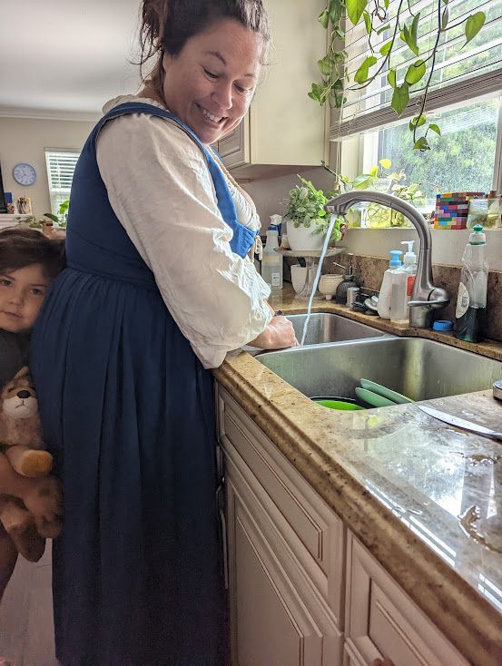 Roya Dedeaux washing dishes in costume