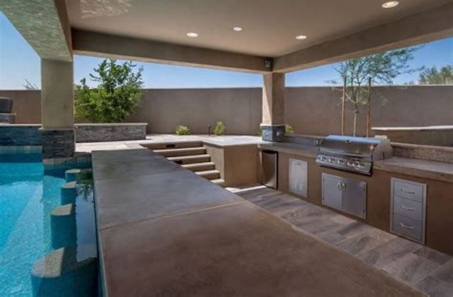 Outdoor covered patio with pool, built-in grill, and bar seating under a modern roof