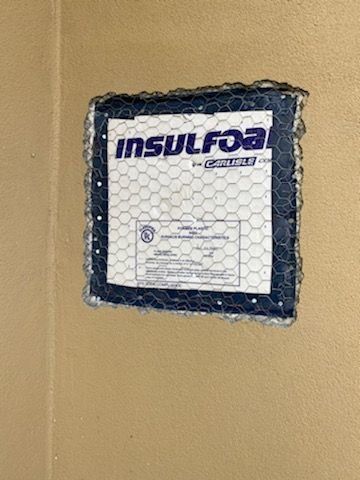 InsulFoam insulation label on a tan wall, covered with protective mesh wrapping