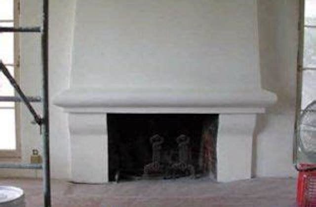 White fireplace in a room with a beige floor and windows on both sides