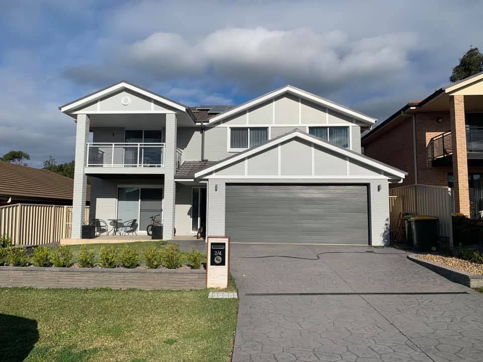 A large white house with a gray garage door — Karl Witt Painter & Decorator In Albion Park, NSW