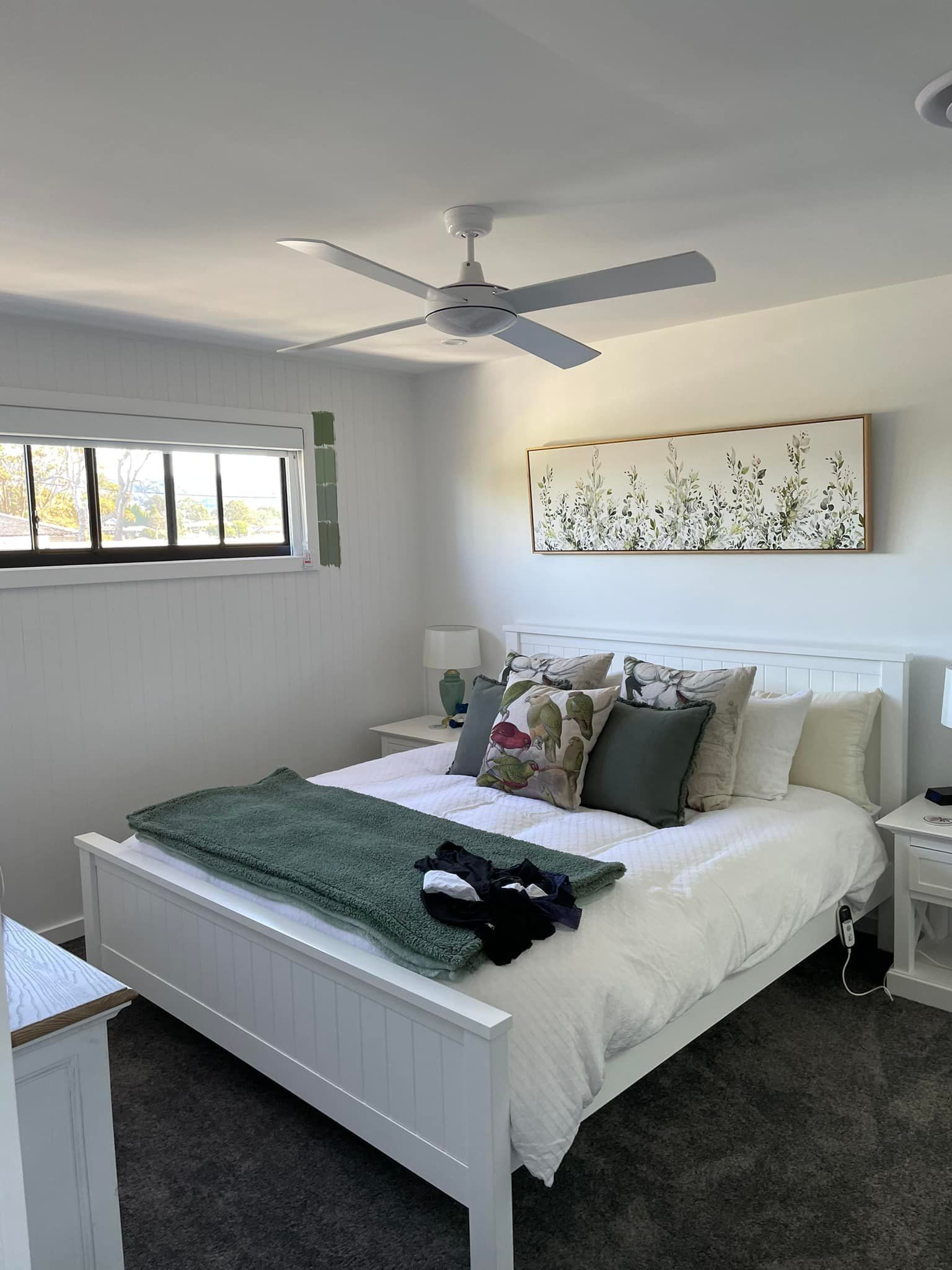 A Bedroom With a Bed , Nightstand , Ceiling Fan and Window — Karl Witt Painter & Decorator In Albion Park, NSW