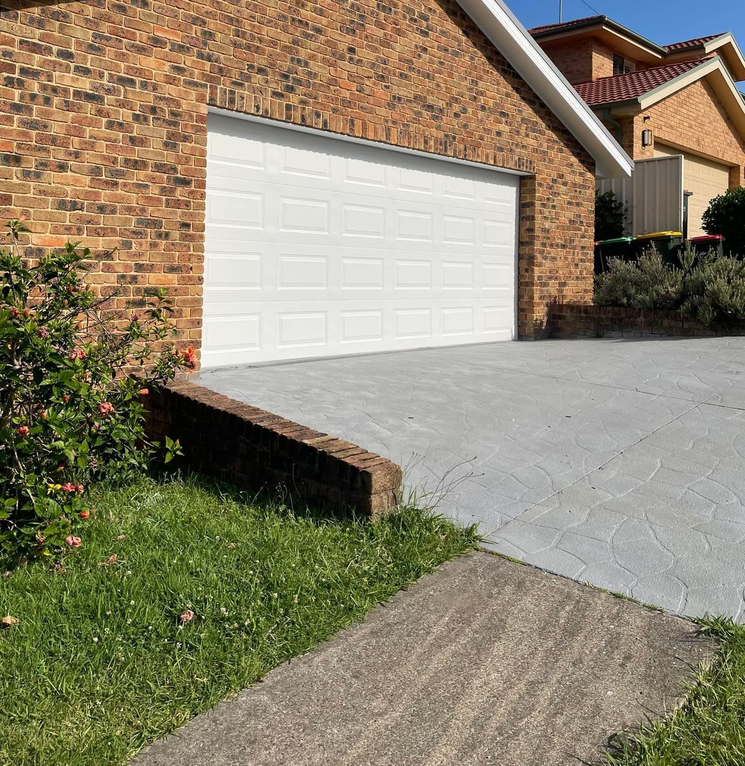 A brick house with a white garage door — Karl Witt Painter & Decorator In Albion Park, NSW