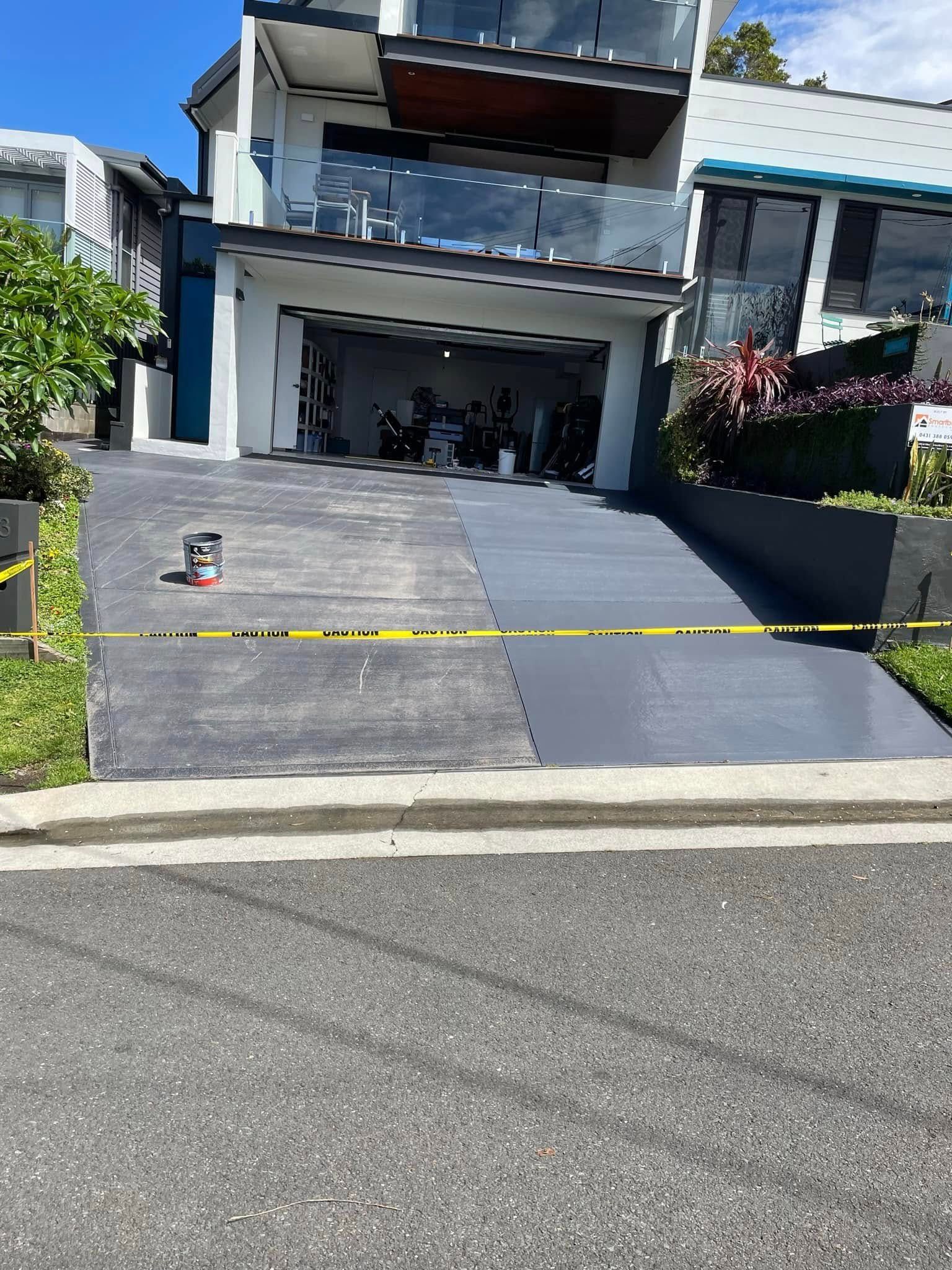 A Driveway is Being Painted in Front of a House — Karl Witt Painter & Decorator In Albion Park, NSW