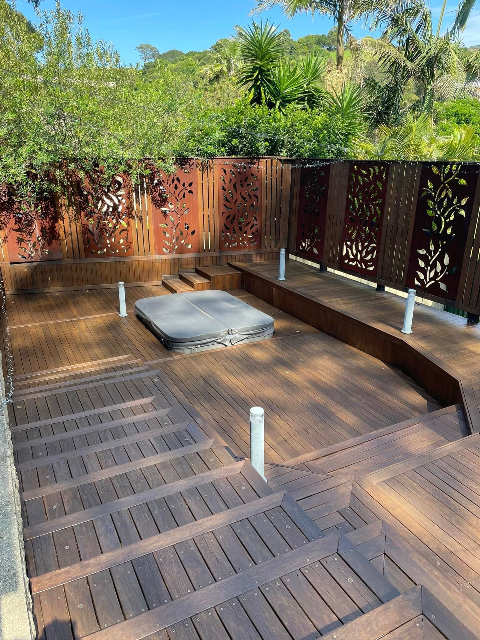 A wooden deck with stairs leading up to a hot tub — Karl Witt Painter & Decorator In Albion Park, NSW