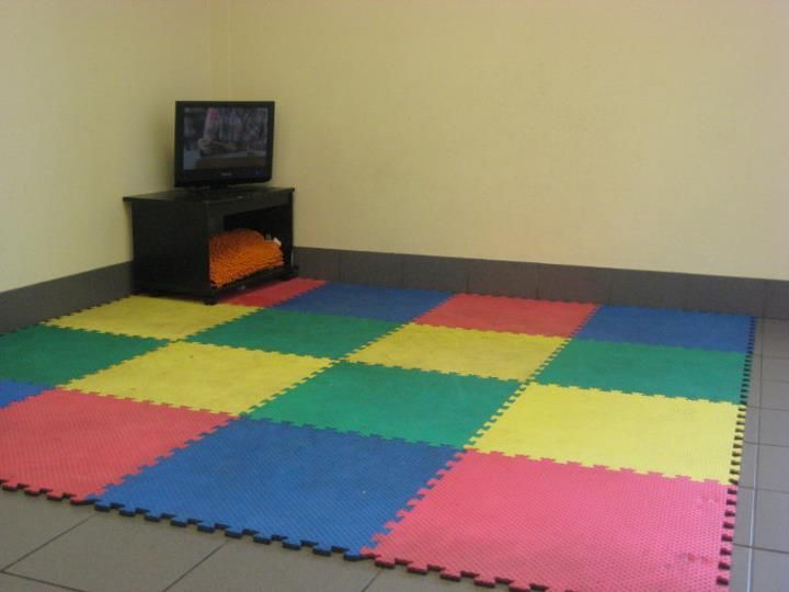 A room with a colorful puzzle mat and a flat screen tv