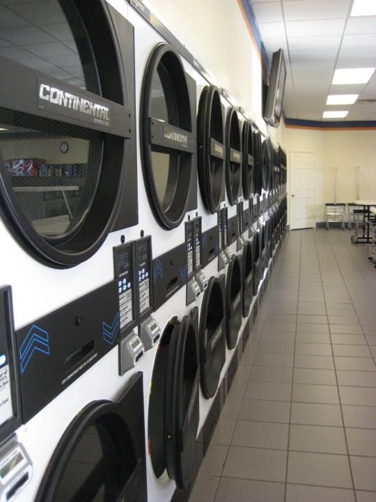 A row of washers and dryers in a laundromat