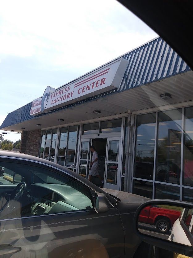 A car is parked in front of a laundry center
