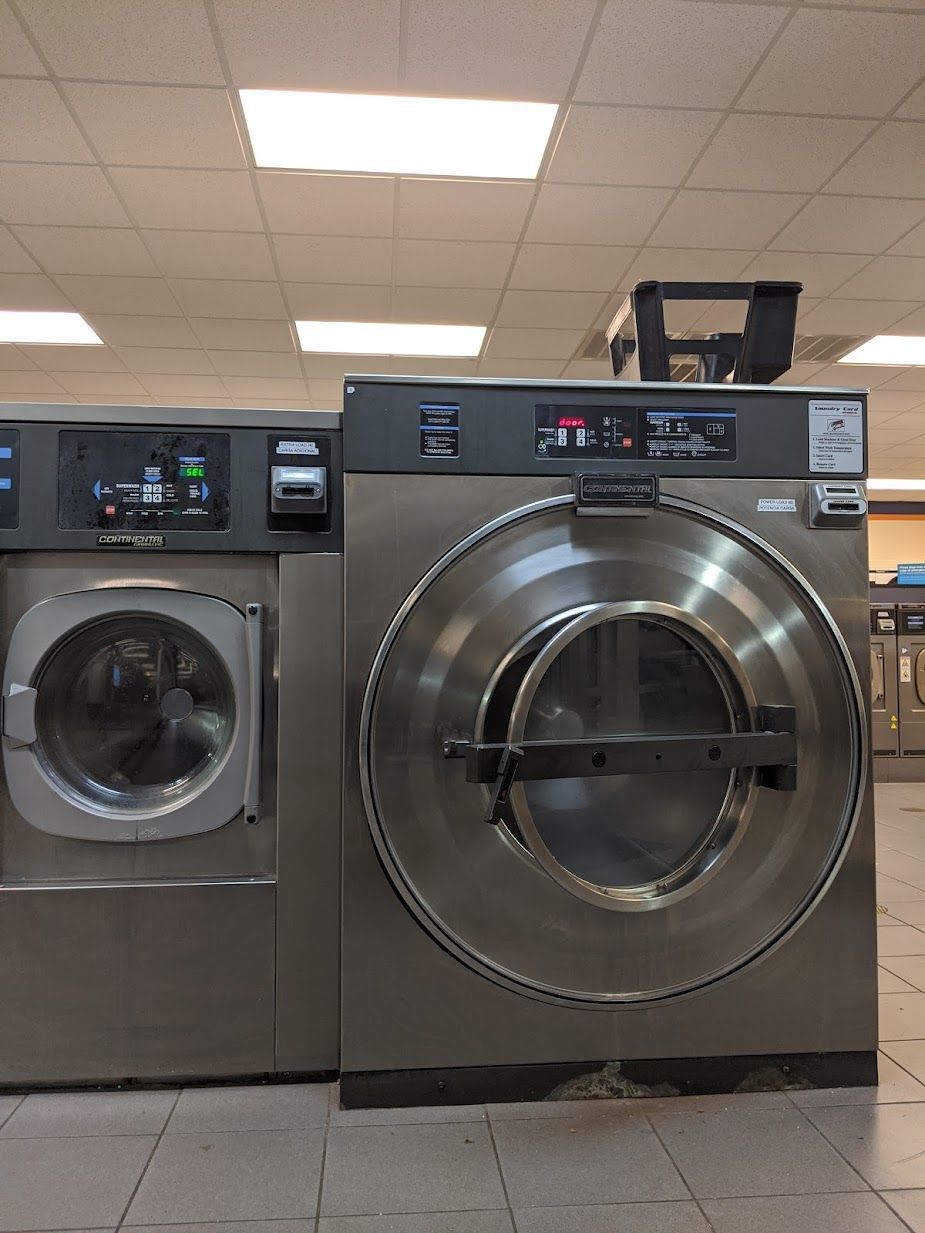 A washer and dryer are in a laundromat