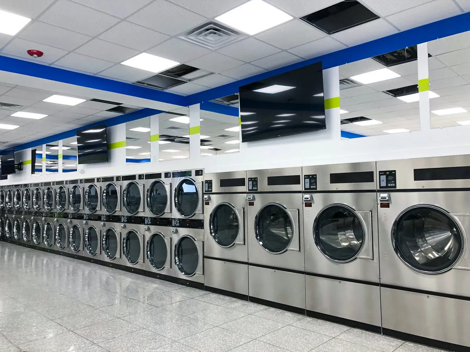 A laundromat filled with lots of washing machines and dryers.