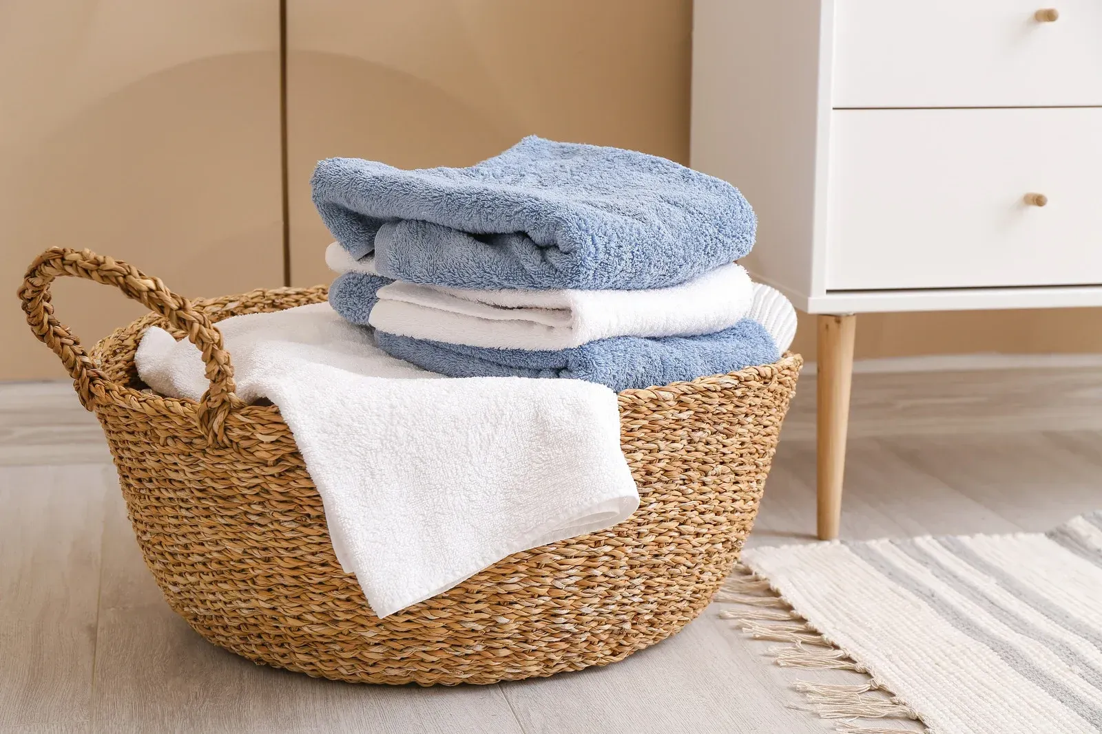 A wicker basket filled with towels in a bathroom.
