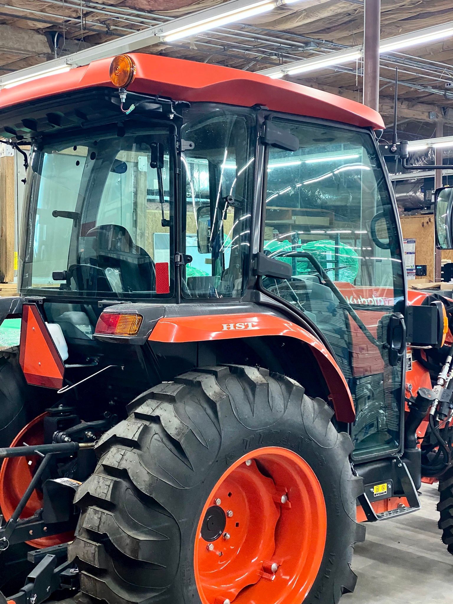Rear view of an orange Kubota tractor inside a building.