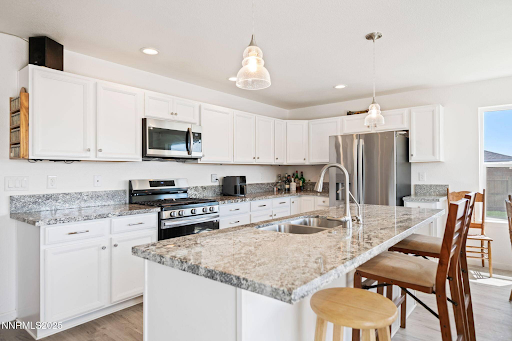 A kitchen with white cabinets and granite counter tops