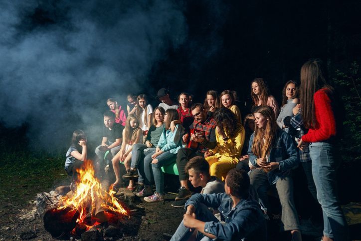 Children singing near camp fire