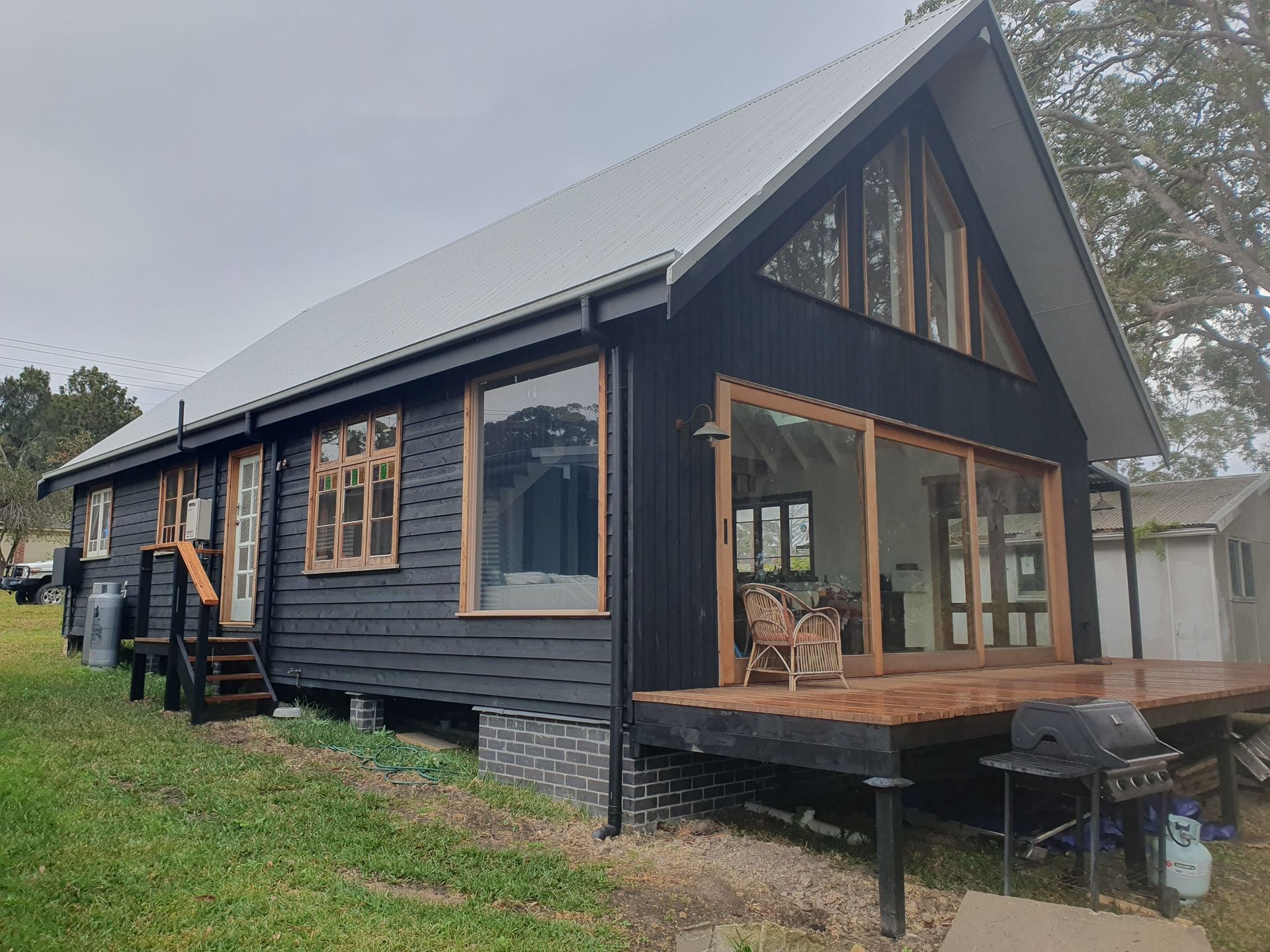 House under construction; brick facade, scaffolding, ladder, and construction materials.