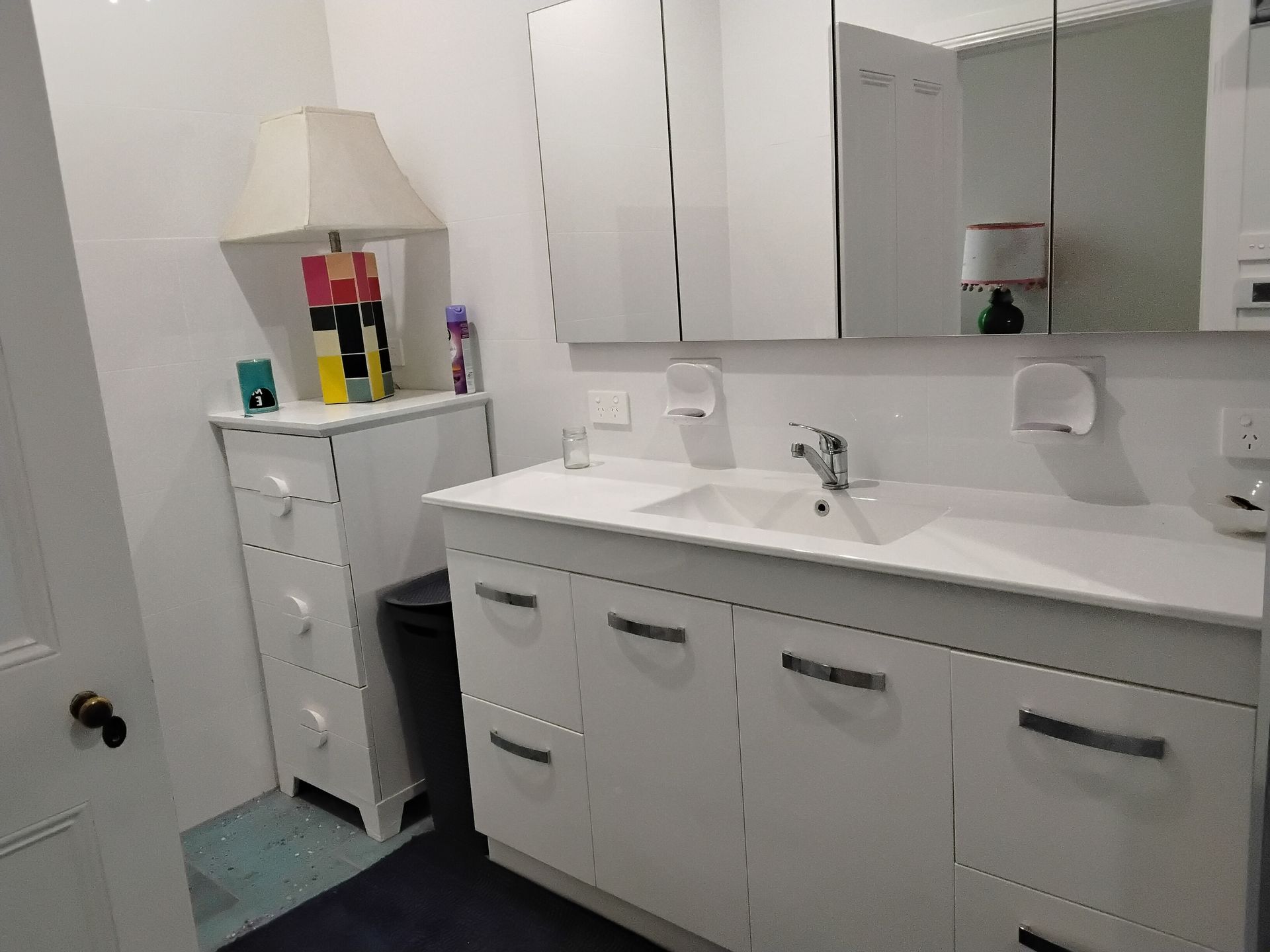 Interior of a decaying barn; wooden beams, corrugated roof, sunlight streaming through openings, dusty floor.