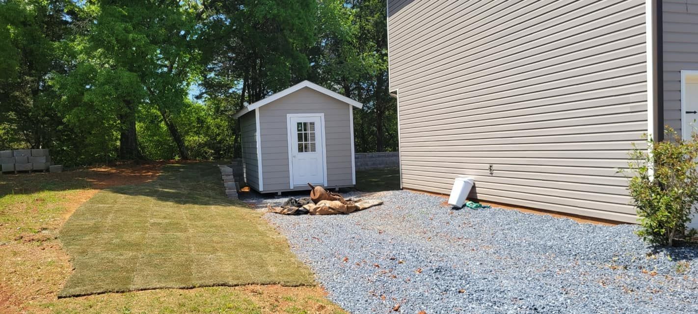 A small shed is sitting in the backyard of a house.