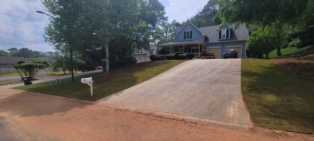 A house with a driveway and a mailbox in front of it.