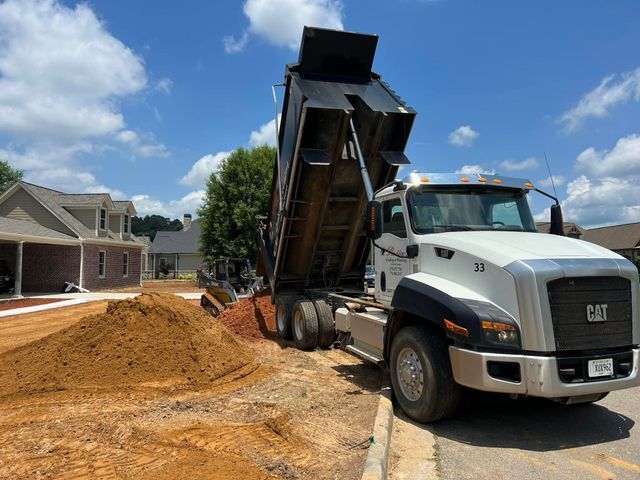 A dump truck is dumping dirt on a construction site.