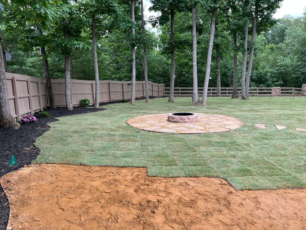 There is a fire pit in the middle of the backyard.