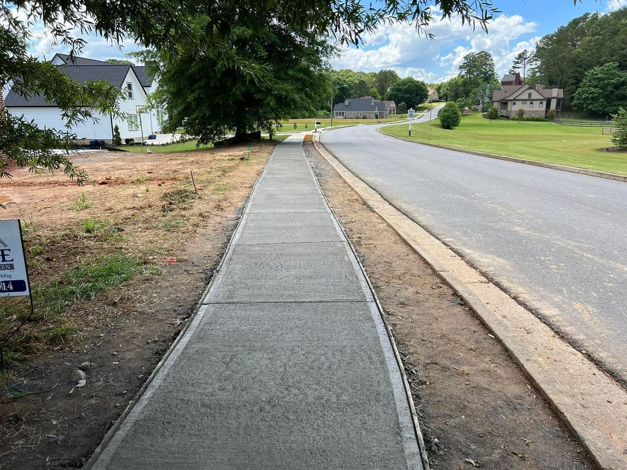 A sidewalk is being built on the side of a road