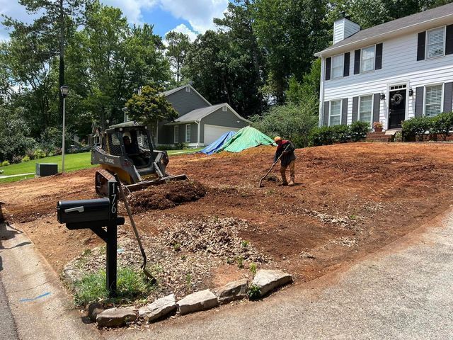 A man is digging in the dirt in front of a house.