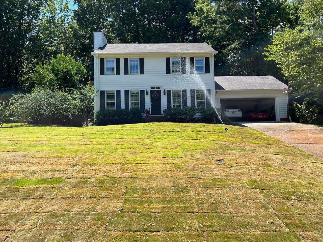 A large white house with a large lawn in front of it.